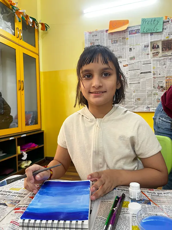 A camper smiling over her blue watercolour painting