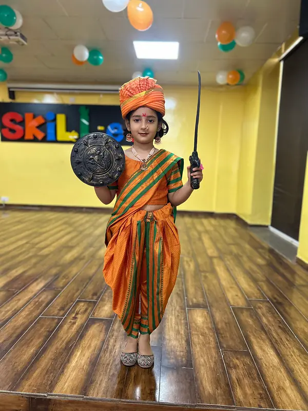 A girl dressed as Rani Lakshmibai with a sword and shield