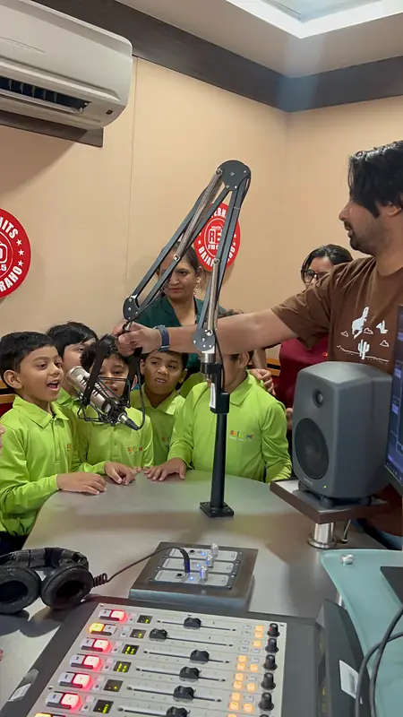 Students watch a radio jockey at the studio console