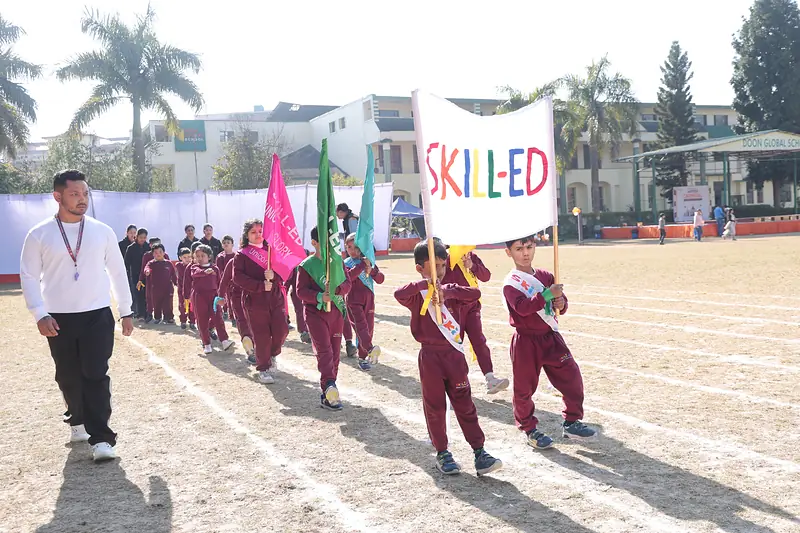 Students lead the march past with the Skill-ed banner