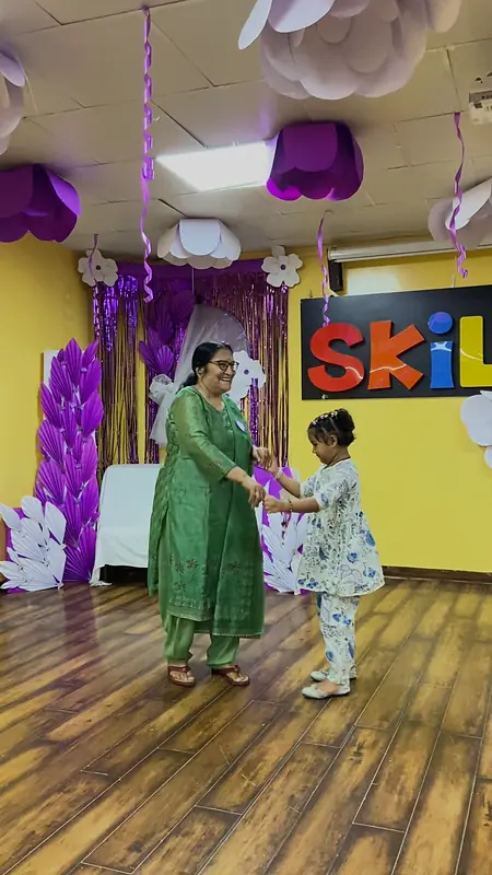 A grandmother and grandson dance on the hall floor